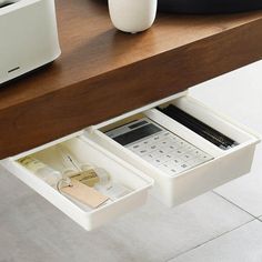 the drawer is open to reveal a calculator and other items on the table