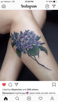 a woman's legs with purple flowers on the side and green leaves around them