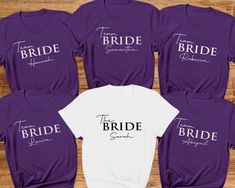 Personalised Hen Party T-shirts. Hen party Tees Bride Tribe, Team Bride, Bridal Party Shirts, Bachelorette T-shirts. Wedding tops Hen Party.  Introducing our fabulous Hen Party T-shirt in Beautiful Purple and white! Made with love from 100% cotton, this tee is the perfect addition to any bride and bridesmaid squad, ensuring you look and feel incredible during all your pre-wedding celebrations.  The bride's shirt is a classic white with a beautiful black print. The other hen party members' t-shirts are a stylish Purple colour with a crisp white print. These shirts are not only fashionable but also practical, as they can be worn by both men and women in your group so can give a relaxed fit feel. - Custom: Each t-shirt is carefully handmade to match your bridal party's unique style. We pay at Cheap T-shirt For Hen Party In Summer, Fitted White Top For Bridesmaid, White Fitted Top For Bridesmaids, White Fitted T-shirt For Bachelorette Party, White Crew Neck Top For Bridesmaids, White Short Sleeve Top For Hen Party, White Short Sleeve Top For Bridal Shower, Fitted White Top For Bridal Shower, White Fitted Top For Bridal Shower