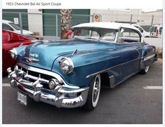 an old classic car parked in a parking lot