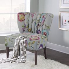 a chair with a blanket on top of it in front of a window and rug