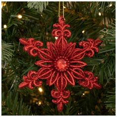 a red ornament hanging from a christmas tree