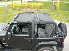 a black jeep is parked on the side of the road with it's doors open