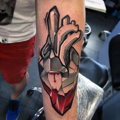 a tattoo on the arm of a person with a red heart and knife in it