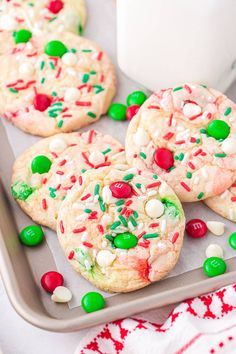 christmas sprinkle cookies on a cookie sheet with green and red candies around them