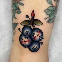 a tattoo with three cherries on it