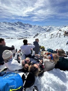 a group of people sitting on top of snow covered ground