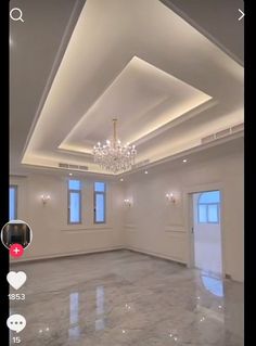 an empty room with a chandelier hanging from the ceiling