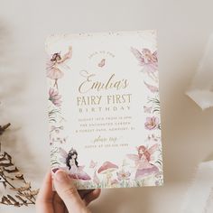 a person holding up a birthday card with flowers on it and the words enthuss fairy first written in gold