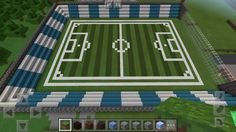 an aerial view of a soccer field in the minecraft game, with blue and white stripes on it