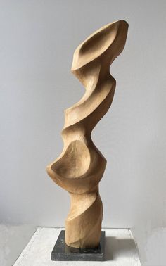 a wooden sculpture sitting on top of a white table