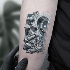 a man's arm with a tattoo on it and an image of a bearded man