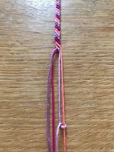 a pink and purple string on a wooden table