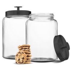 two glass jars with cookies in them next to one cookie jar and the lid is black