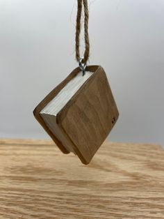 a wooden object hanging from a rope on top of a table