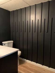 a bathroom with black cabinets and white toilet