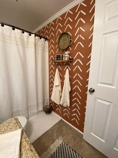 a bathroom with two towels hanging on the wall and a towel rack in front of the door