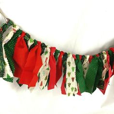 a red and green christmas garland is hanging on a white wall with polka dot trim