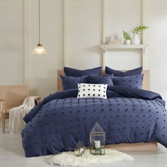 a bed with blue comforters and pillows in a room