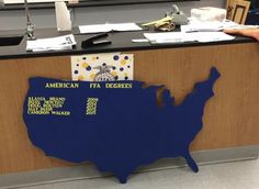 an office desk with a sign on it that says american fea degrees and the map of the united states