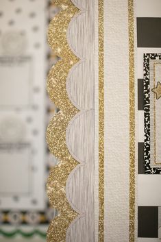 gold and white wallpaper with black and white striped design on the bottom half of it