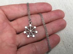 "This is such a sweet and stylish silver snowflake pendant necklace. It is the perfect everyday size, wear it all winter long! It would make the perfect gift for any snow and winter loving person. Pray for snow! The snowflake measures 5/8\" long by 1/2\" wide and hangs from a simple 18\" stainless steel necklace chain with a lobster clasp. I have matching earrings in my shop, if you would like the whole set! Here is the link https://etsy.me/2AwKBzN Thanks for stopping by! Please take a moment an Silver Necklaces For Winter Holidays, Winter Snowflake Necklace, Perfect For Gifts, Winter Snowflake Necklace, Necklace Snowflake, Acorn Jewelry, Green Tassel Earrings, Snowflake Jewelry, Snowflake Necklace, Silver Statement Earrings