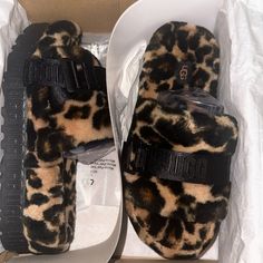 Leopard Print Ugg Sandals Brown Synthetic Slides With Flat Heel, Trendy Brown Synthetic Slides, Brown Flat Slippers With Buckle Closure, Trendy Brown Slip-on Slides, Brown Platform Slip-on Slides, Trendy Brown Flat Slides, Brown Platform Slides With Round Toe, Leopard Print Platform Sandals With Round Toe, Ugg Sandals