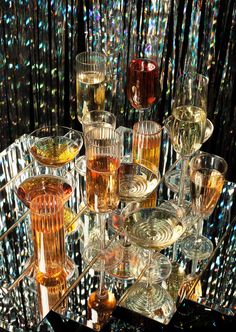 a table topped with lots of glasses filled with different types of liquid and drinks on top of each other