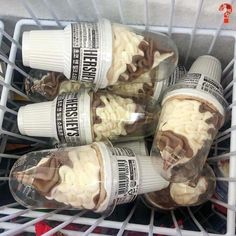 four cups filled with food sitting on top of a shelf in a store display case