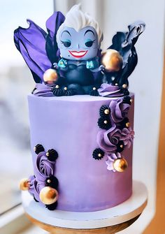 there is a purple cake with an evil face on it and decorations around the edges