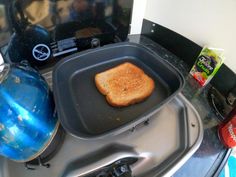 a toasted sandwich sitting on top of a frying pan next to a water bottle