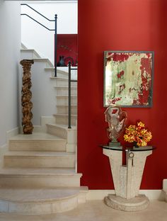 there is a vase with flowers sitting on the table in front of the staircases