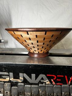 a wooden bowl sitting on top of an old typewriter's manual book machine