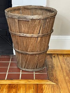 a wooden basket sitting on the floor in front of a door with a brick walkway