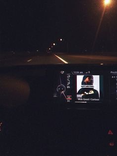 the dashboard of a car at night with lights on and an image of a person driving