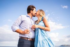 a man and woman kissing on the beach