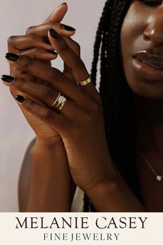 a woman holding her hands up to her face with the words melanie casey fine jewelry