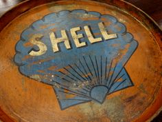 an old wooden barrel with the word shell painted on it's side and sunburst at the bottom