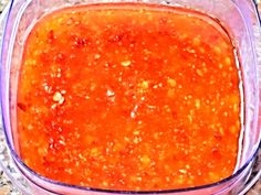 a glass container filled with red sauce on top of a counter