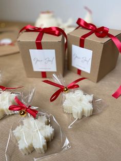 three boxes with small pieces of food wrapped in cellophane and tied with red ribbon