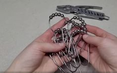 a person holding several pairs of scissors in their hands with some wire attached to them