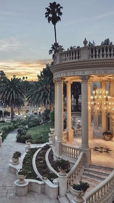 an outdoor gazebo surrounded by palm trees at dusk