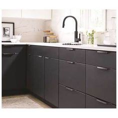 a kitchen with black cabinets and white counter tops