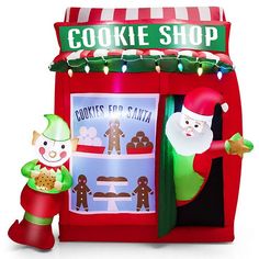 an inflatable cookie shop with santa claus and gingerbread man standing next to it