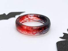 ❤️ Blood Red Resin Ring  ❤️ A vampire-inspired resin ring with black and red swirling resin. ✨ Perfect for your witchy-halloween outfits, or just regular dark academia inspired fits 🩸 matching jewelry is available on my page 🪄 These are lovingly handmade to order so each will be a little unique.  SIZING  For a ring size conversion, please copy this link into your browser http://en.wikipedia.org/wiki/Ring_size Resin is a lightweight material and doesn't slide around as much as heavier materials Red Rings For Halloween Gift, Black And Red Rings, Vampire Rings, Blood Ring, Vampire Ring, Vampire Fashion, Witchy Gifts, Witchy Halloween, Red Rings