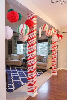 red, white and green striped paper lanterns hanging from the ceiling in a living room