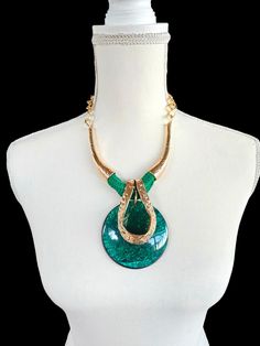 This Green Retro Chunky Necklace is a bold statement piece featuring a large, stylish pendant. The vibrant green hue of the pendant is complemented by sleek gold metal accents, creating a perfect balance of elegance and retro charm. Ideal for adding a pop of color and sophistication to any outfit, this necklace is a must-have for those who love eye-catching, vintage-inspired jewelry. Big Pendant Necklace, Big Pendant, Bold Statement Necklaces, Necklace Big, Green Retro, Vintage Inspired Jewelry, Metal Necklace, Necklace Green, Metal Accents