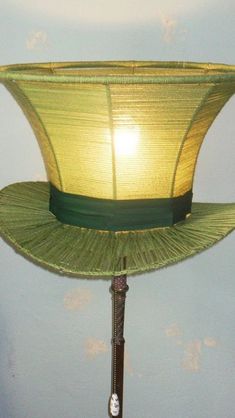 a lamp that is sitting on top of a wooden stand with a yellow shade over it