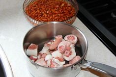 some food is being cooked in a pot on the stove top next to another pan