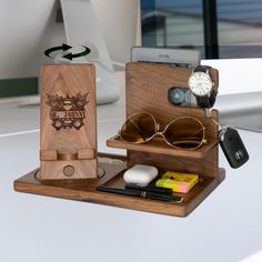 an assortment of personal items are arranged on a desk top with a phone and other accessories